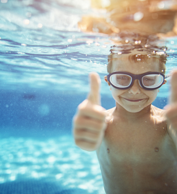 Kid Swimming giving thumbs up.