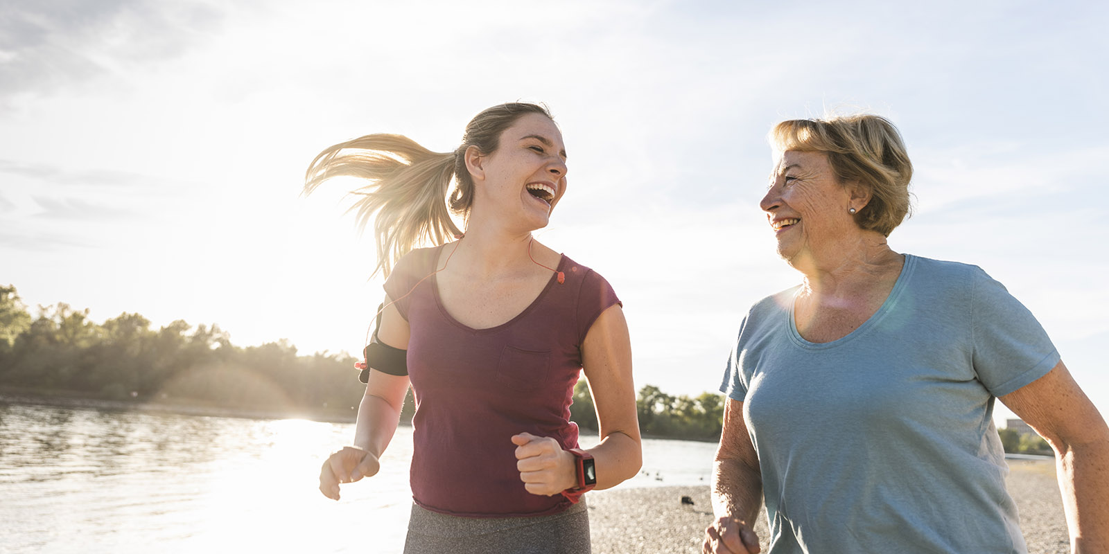 Granddaughter and grandmother having fun, jogging together at the river